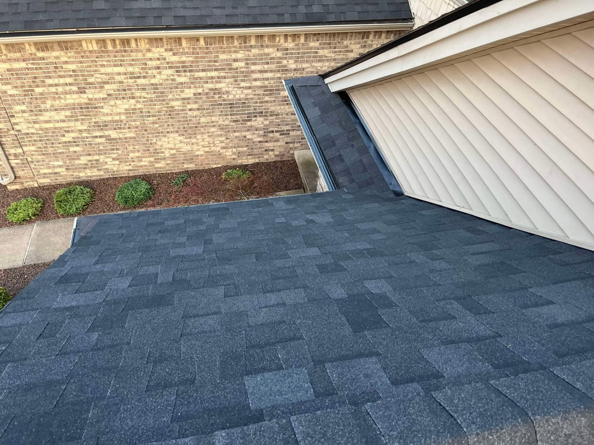 Fresh shingles at garage valley and step flashing