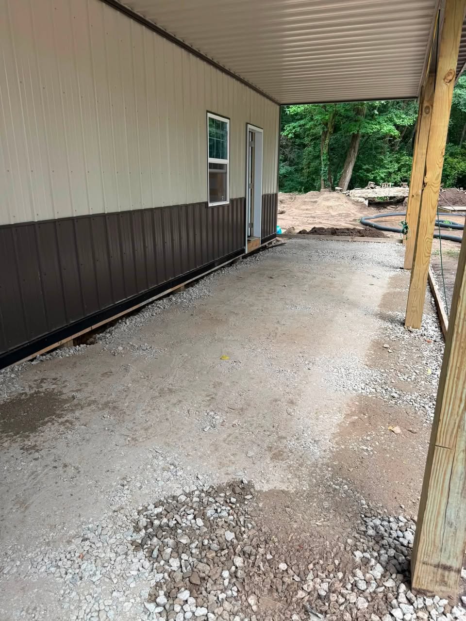 Pole barn covered porch with fresh gravel base and posts set