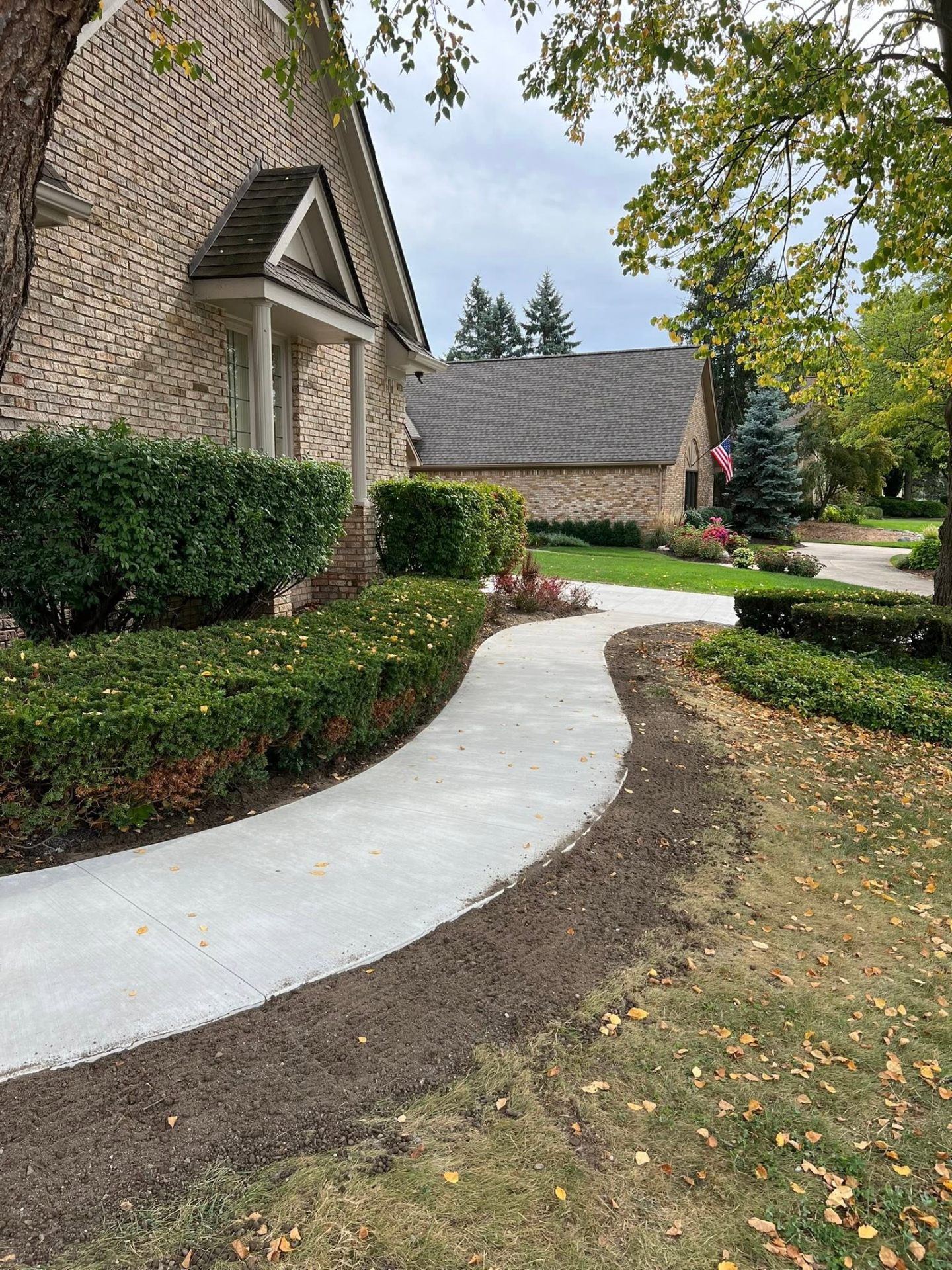 New curved concrete walkway leading to the Plymouth home's front entry