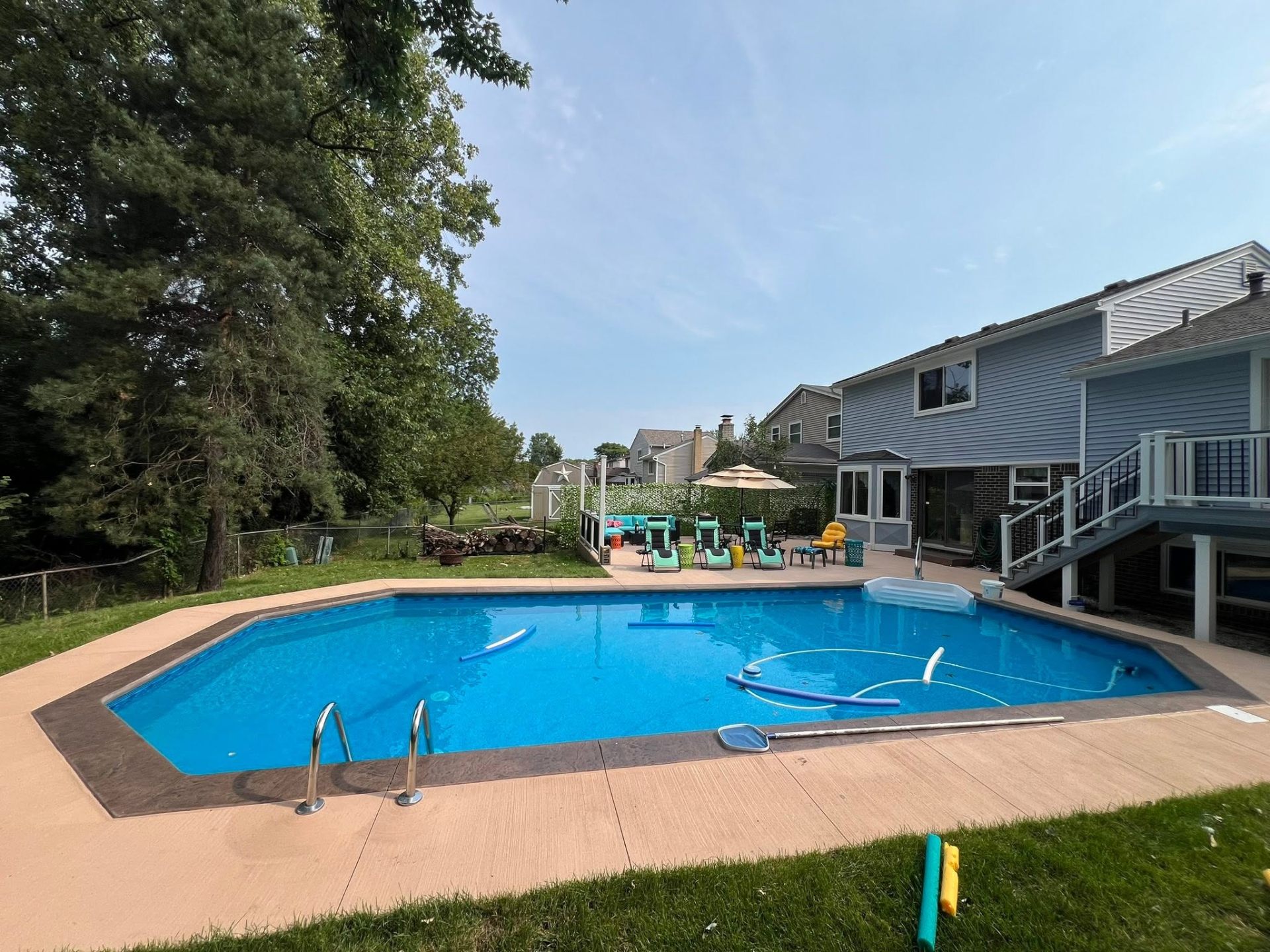 Backyard in-ground pool with wraparound stamped concrete pool deck