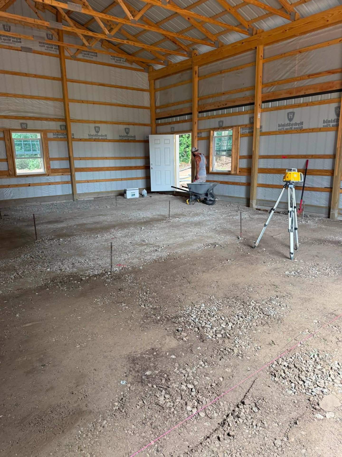 Pole barn interior — rotary laser set and gravel base graded
