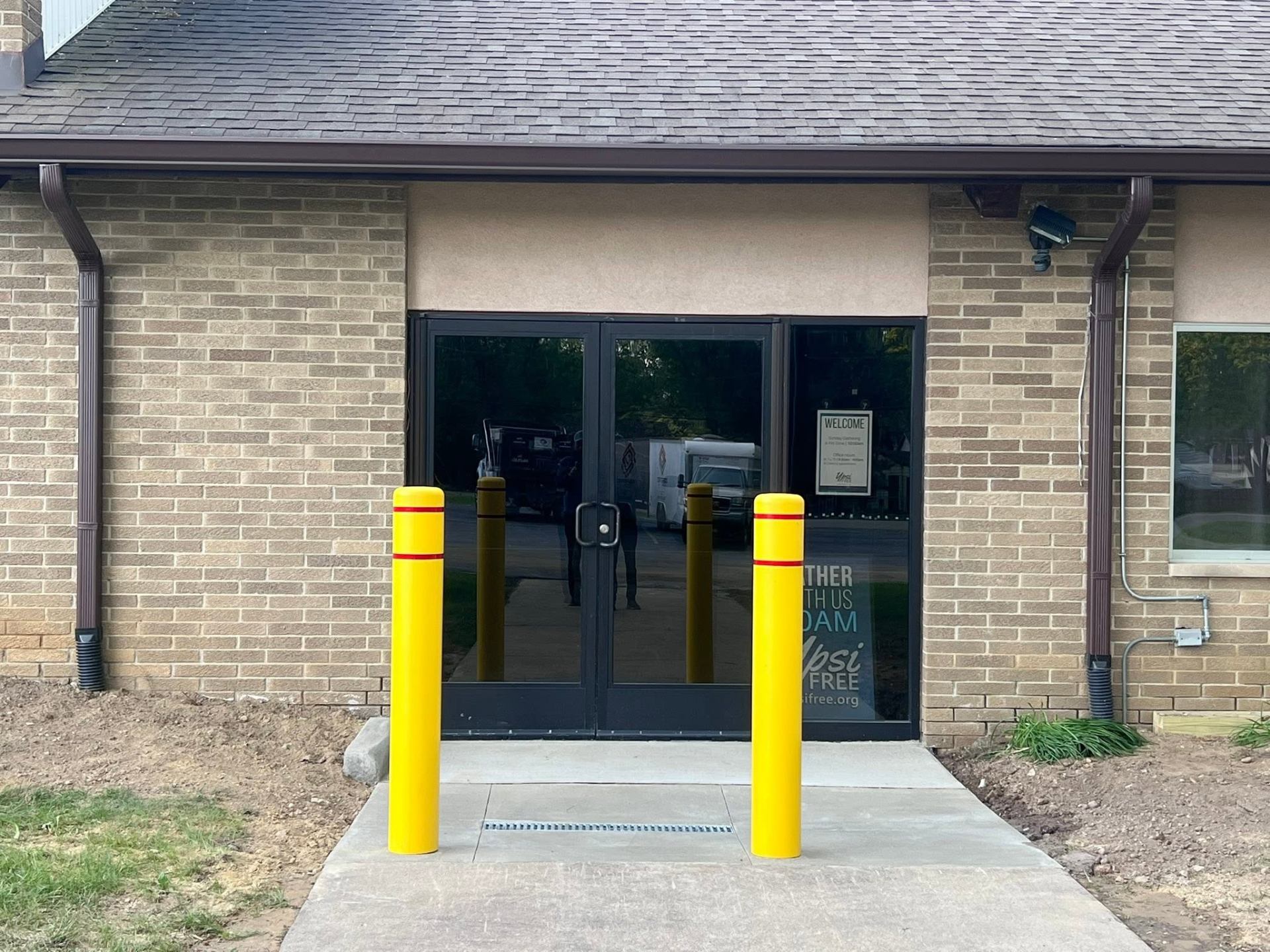 Safety bollards and channel drain at building entry
