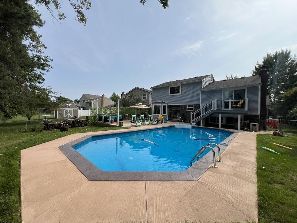 In-ground pool with stamped border and broom-finish concrete deck