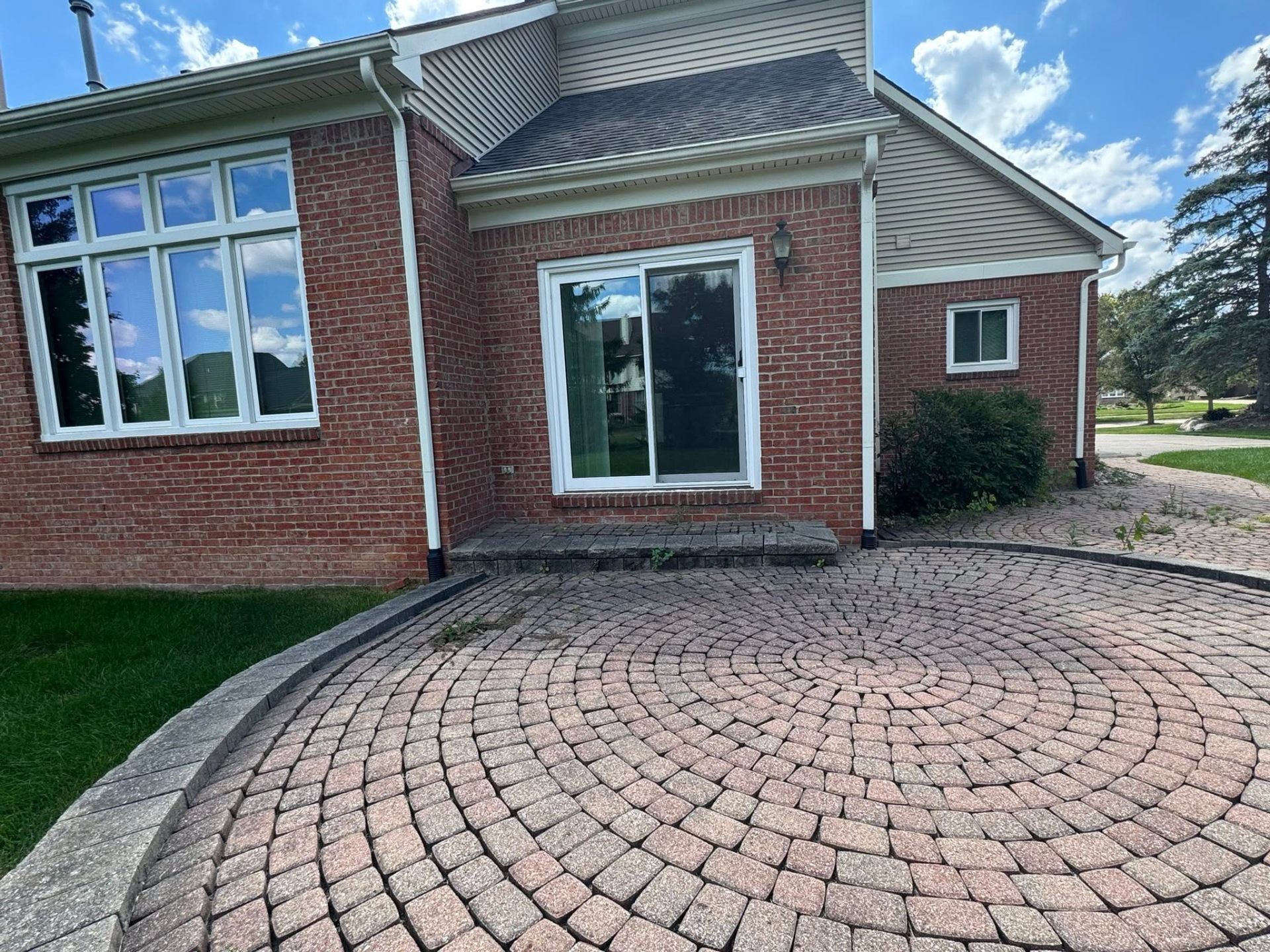 Finished circular brick paver patio at brick home