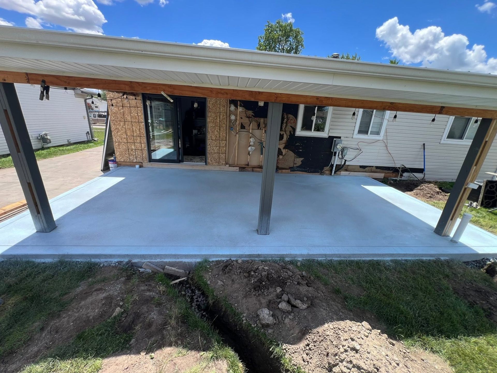 Fresh exposed aggregate patio under covered pergola with post beams
