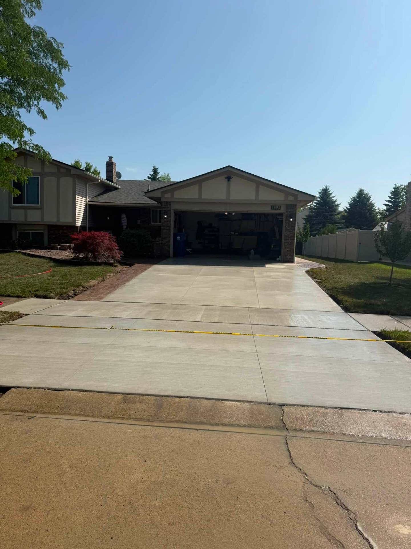 Finished concrete driveway with brick paver border to garage